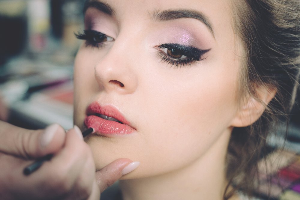 Maquilladora aplicando pintalabios a una clienta