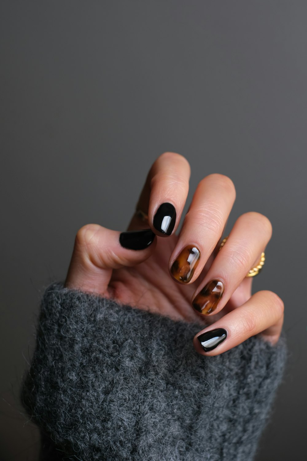 Mano con manicura en negro y efecto carey