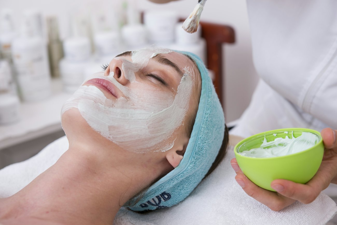 Clienta recibiendo un tratamiento facial con los ojos cerrados